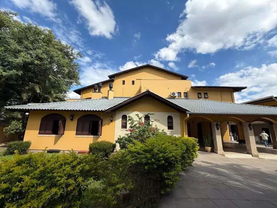 Fachada amarela do Ilê Oxum Docô, cercada por árvores e jardim
